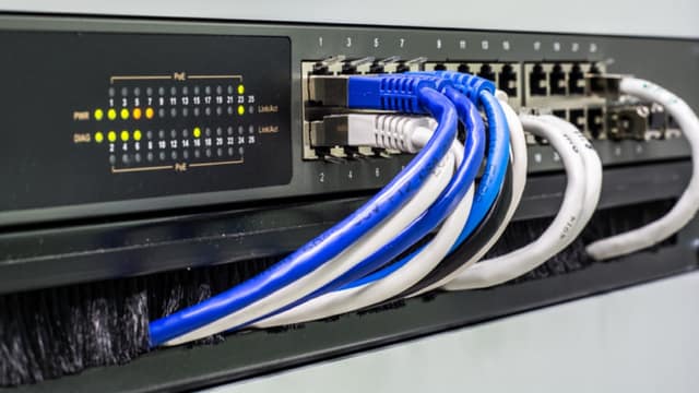 Rack-mounted switch with copper Ethernet cables dressed into a brush manager